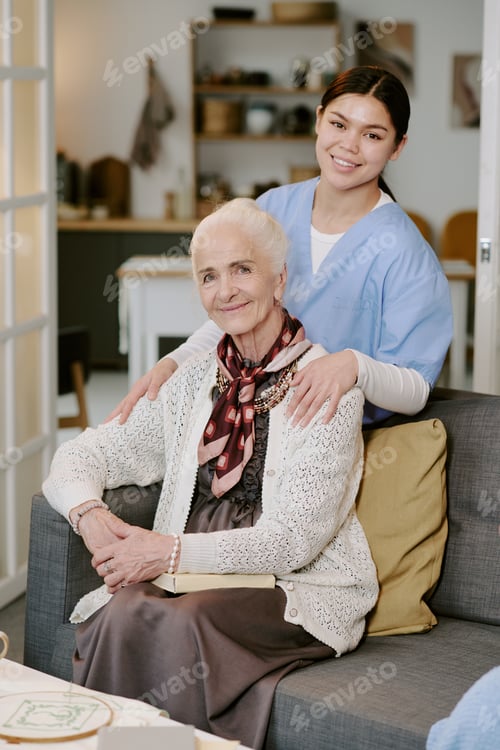 Preview: Senior Woman Sitting with Young Hispanic Female Caregiver Smiling