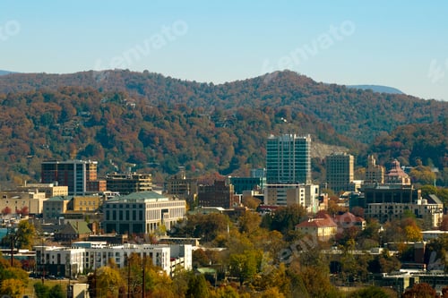 Preview: Aerial view of Asheville city in North Carolina with high buildings and mountain hills in distance