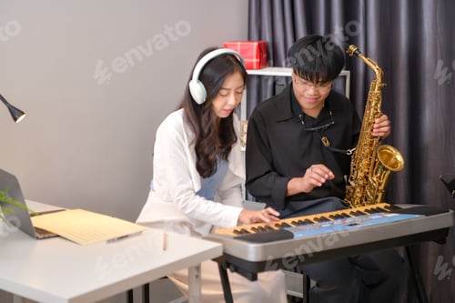Visualização: Dois jovens asiáticos tocando música em ambientes fechados com teclado e saxofone