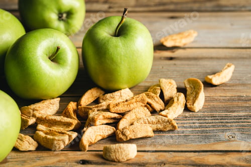 Preview: Homemade dried organic apple and and raw green apples on a wood background.