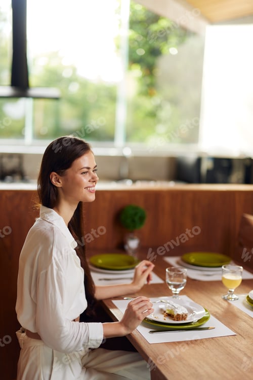 Preview: Happy Woman Enjoying a Romantic Dinner at Home with a Delicious Cake and Wine