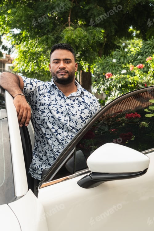 Preview: Confident man standing by car outdoors during day