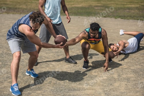 Preview: group of young multicultural men playing football on court