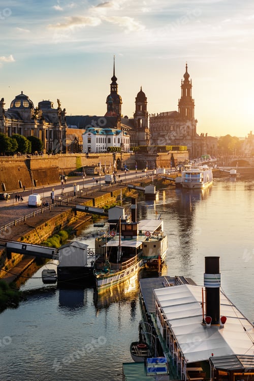 Preview: Scenic warm sunset beautiful Dresden city skyline at Elbe River with many steam tourist ship vessel
