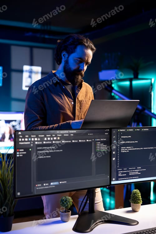Preview: Software engineer checking code displayed on computer monitors in apartment