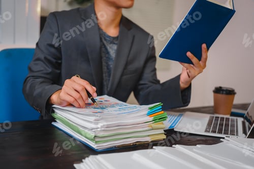 Preview: A businessman works late at his desk, focused on his laptop while talking online.checks important