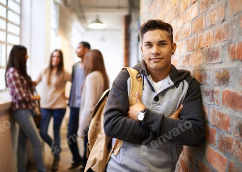 Preview: Portrait of a handsome young male student leaning against a wall with his friends in the background