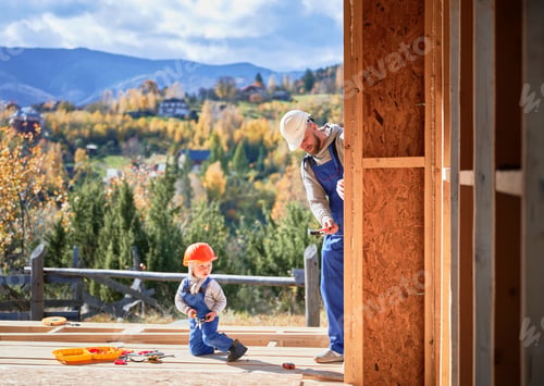 Preview: Father with toddler son building wooden frame house.