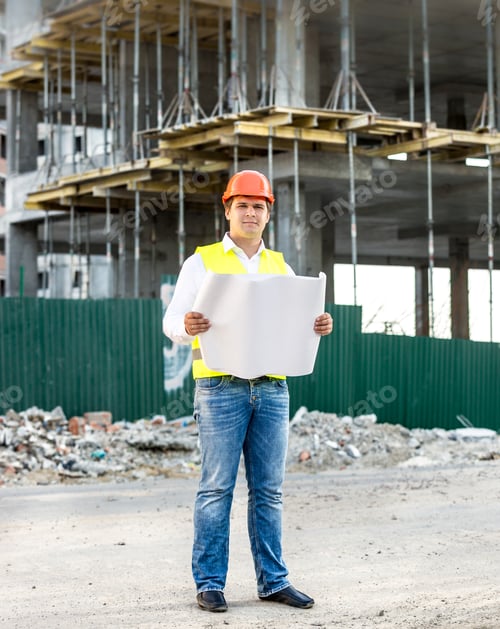 Preview: architect at work reading blueprints on building site
