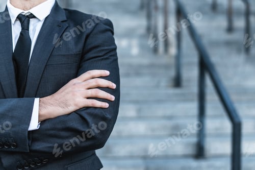Preview: Close-up businessman crossing his hands posing against the background of the office stairs