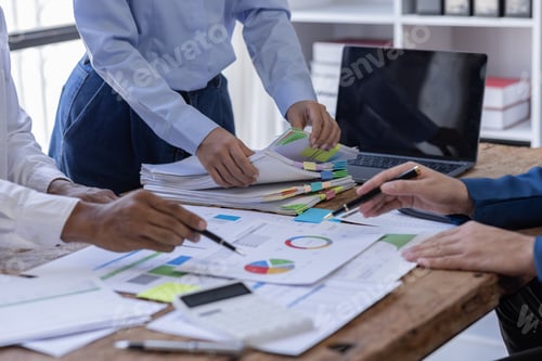 Preview: Team of confident business people point to graphs and charts to analyze market data, balance sheet,
