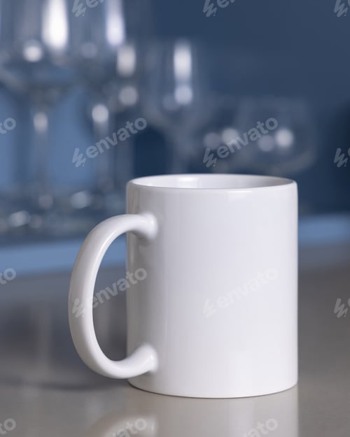 Preview: White coffee mug on grey kitchen table against blue wine glasses holder closeup, mockup