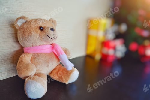 Preview: Celebration concept, A doll bear sitting near gifts and Christmas tree with wooden background.