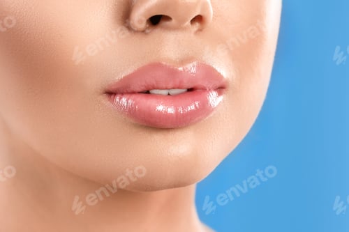 Preview: Young woman with beautiful full lips on light blue background, closeup