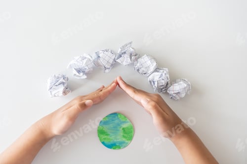 Preview: Reuse paper to protect the world. Reduce the amount of using paper. Kid hands protect the world.