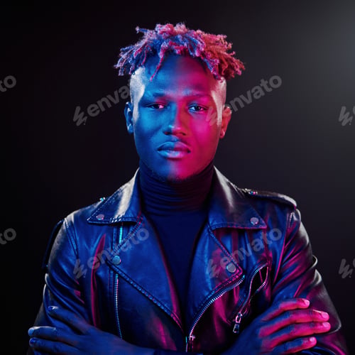 Preview: Futuristic neon lighting. Young african american man standing in studio with arms crossed