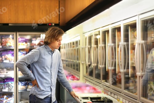 Preview: Man Choosing Frozen Food From A Supermarket Freezer