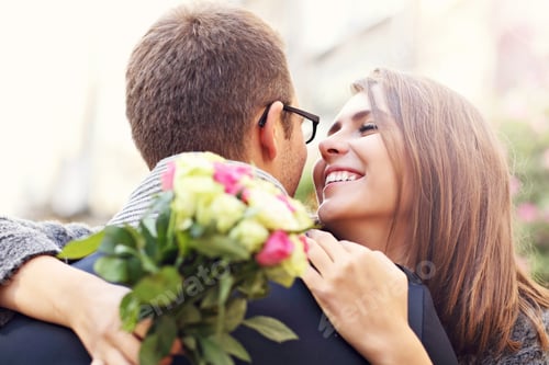 Preview: Woman with flowers giving hug to her man