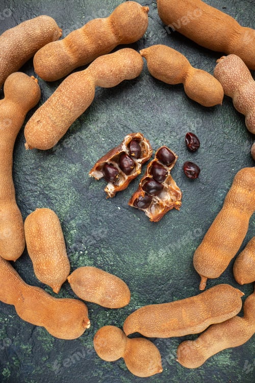 Preview: Top view of peeled dried bean arranged in round shape on dark color distressed background with free