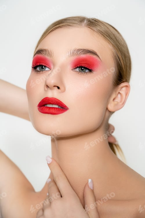 Preview: Young model with red visage touching neck isolated on grey