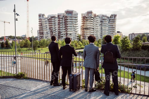 Preview: Four professionals observing the cityscape from a bridge