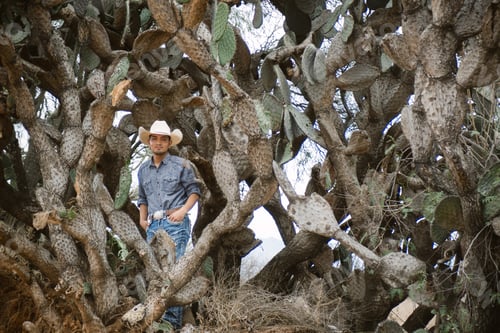 Preview: Smiling cowboy wearing a hat and sunglasses, enjoying outdoor adventures with a sense of fun