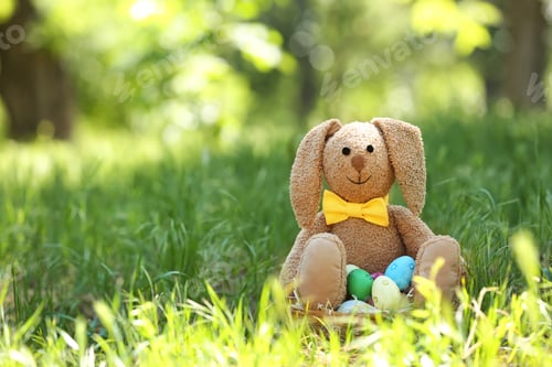 Preview: Toy bunny and basket with Easter eggs on grass
