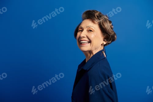 Preview: A radiant woman in her 60s showcases style and grace with a joyful smile.