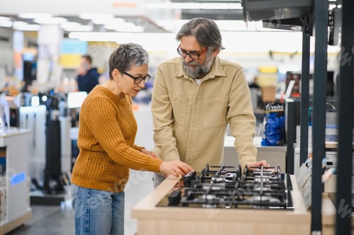 Preview: Senior couple shopping for new kitchen stove in appliance store
