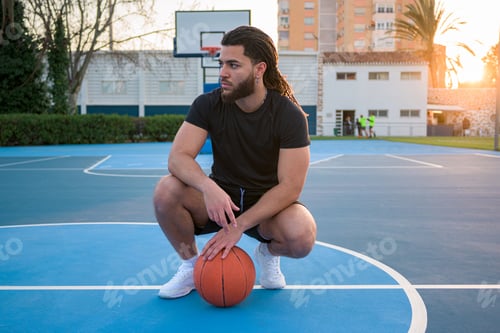 Preview: Portrait of a Latin Afro man posing with a ball on a basketball court