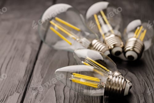Preview: Light bulbs on dark wooden background close up