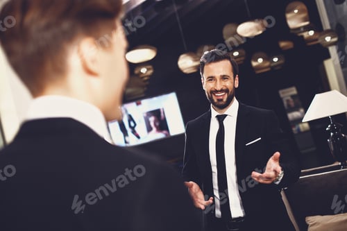 Preview: Friendly Gesture. Happy Emotional Elegant Man In Dark Suit Smiling And Looking Glad While Standing