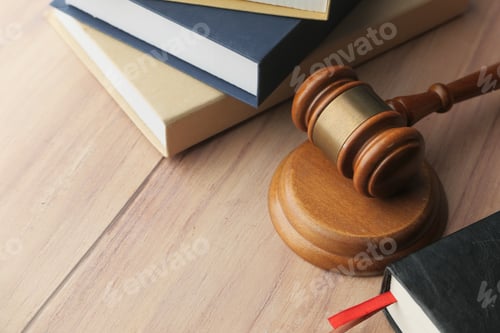 Preview: Judicial System Tools A Gavel and Legal Books Resting on a Wooden Table Surface
