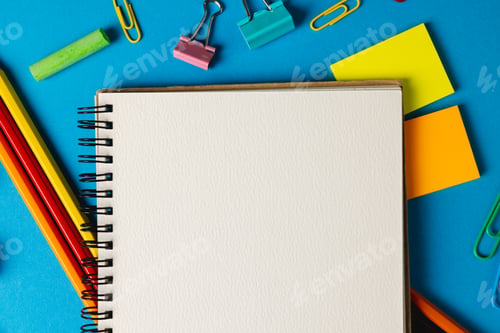 Preview: Composition of school equipment with notebook with copy space on blue surface