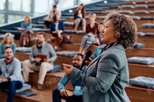 Preview: Mature businesswoman giving a speech during an education event at convection hall.