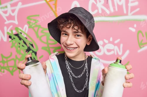 Preview: Handsome cheerful hipster boy poses in city against graffiti background wears black panama shirt sil