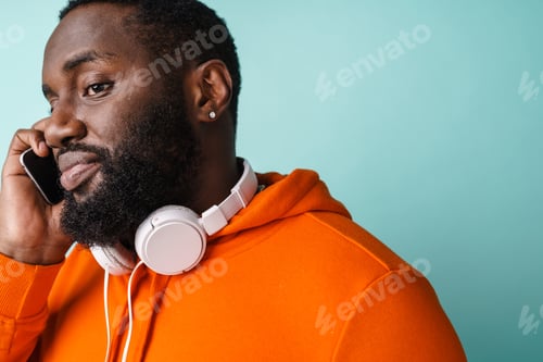 Preview: Smiling young african man talking on mobile phone