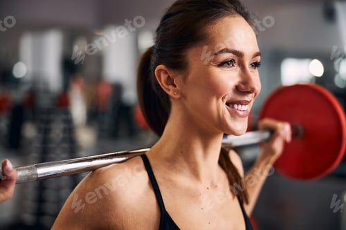 Preview: Close up of cute sportswoman lifting barbell