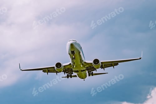 Preview: Low angle shot of an airplane flying against a cloudy blue sky