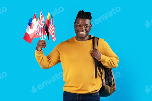 Preview: Portrait Of Smiling Black Male Student With Backpack Holding International Flags