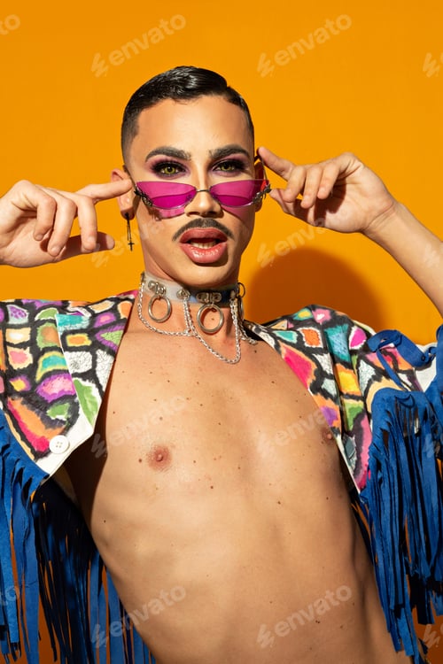 Preview: Young and beautiful drag queen in colorful dress on yellow background