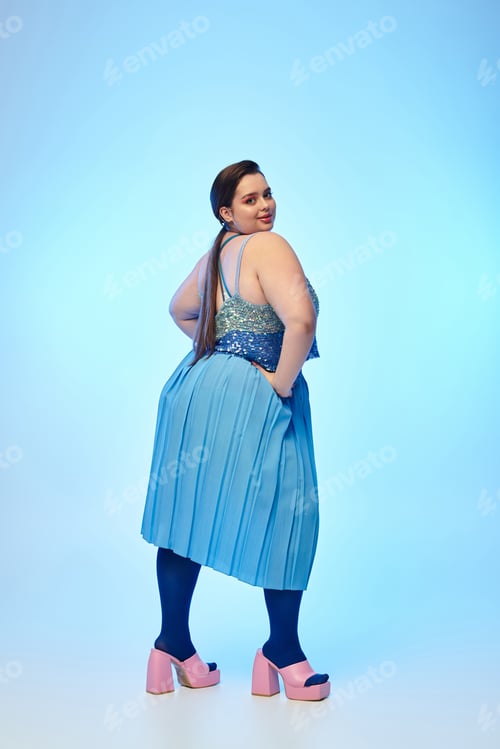 Preview: Beautiful plus size woman showcasing confidence with vibrant fashion in a studio setting