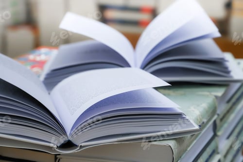 Preview: Open book on table with blur bookshelf background