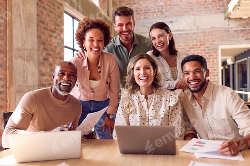 Preview: Portrait Of Multi-Cultural Business Team Meeting Around Laptop In Busy Office