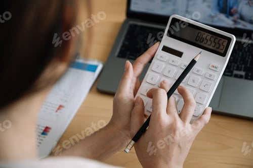 Preview: Close up of businesswoman or accountant hand holding pencil working on calculator to calculate