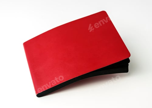 Preview: Closeup of red cover notebook on white table