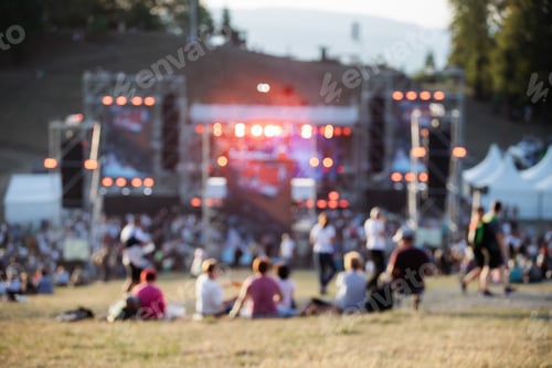 Preview: Blurred background of vibrant outdoor music festival
