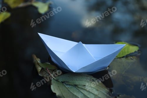 Preview: Paper boat in puddle outdoor in rainy weather