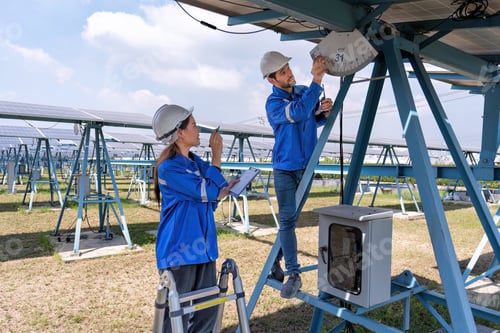 Preview: Maintenance engineer at solar farm stand on structure support checking solar panel angle indicator