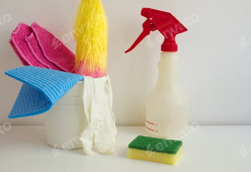 Preview: Container with cleaning items on the white table against white wall